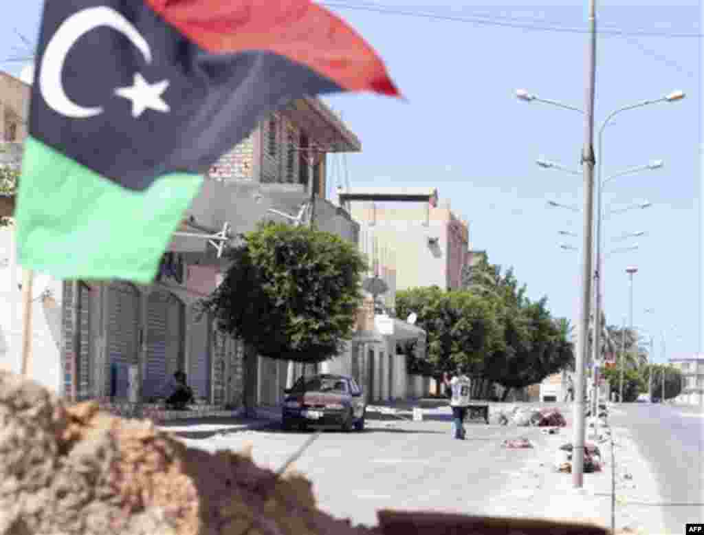 In this Monday, Aug. 15, 2011 photo, a pre-Gadhafi rebel flag flies in Zawiya, western Libya. Since the rebels entered Zawiya last week _ their most dramatic advance yet after months of stalemate in Libya's civil war _ Gadhafi's troops have been pounding 