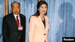 Thailand's Prime Minister Yingluck Shinawatra (R) and Deputy Prime Minister Surapong Tovichakchaikul arrive before a meeting with the Election Commission at the Royal Thai Air Force Academy in Bangkok, Apr. 30, 2014. 