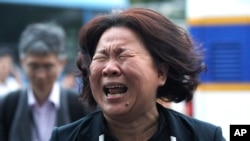 FILE - A family member of passengers aboard the sunken ferry Sewol cries after a pretrial hearing of crew members of the ferry at Gwangju District Court in Gwangju, South Korea, June 10, 2014. 