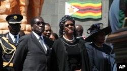 Zimbabwean President Robert Mugabe and his wife Grace attend the burial of Solomon Mujuru, the country's first defense chief and husband of Vice President Joyce Mujuru, August 20, 2011 in Harare