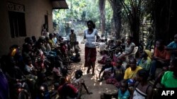 FILE - A volunteer brings daily food rations for internally displaced persons (IDPs), at a camp for IDPs fleeing the conflict in the DRC's Kasai province, in Kikwit, DRC. 