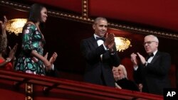 President Barack Obama and first lady Michelle Obama, with financier and philanthropist David Rubenstein, right, applaud during the Kennedy Center Honors Gala at the Kennedy Center in Washington, Dec. 4, 2016. 