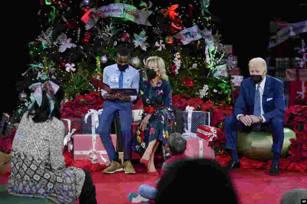 A patient at reads &quot;Olaf&#39;s Night Before Christmas&quot; with first lady Jill Biden as President Joe Biden listens at Children&#39;s National Hospital in Washington, Dec. 24, 2021.