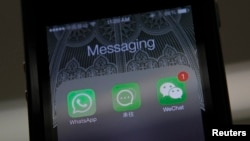 FILE - Icons of messaging applications WhatsApp of Facebook (L), Laiwang of Alibaba Group (C) and WeChat, or Weixin, of Tencent Group, are seen on the screen of a smart phone on this photo illustration taken in Beijing, February 24, 2014. 