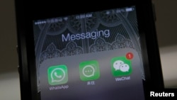 一位中国用户的手机屏幕上显示有WhatsApp、微信以及阿里巴巴开发的聊天软件“来往”。