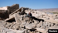 FILE - A Yazidi man walks on the ruins of his house, destroyed by Islamic State militants near Sinjar, Iraq, Feb. 5, 2019. 