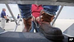 FILE - Shackled Mexican nationals are boarded onto a U.S. Immigration and Customs Enforcement jet for deportation, at O'Hare International Airport in Chicago, Illinois, May 25, 2010. (AP Photo/LM Otero, File)