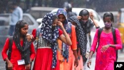 People walk in the rain in Hyderabad, India, Nov. 20, 2021.