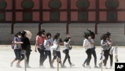 Anak-anak sekolah di Korea Selatan memakai masker untuk mencegah terjangkit virus MERS saat mereka mengunjungi Istana Gyeongbok di Seoul (3/6). (AP/Ahn Young-joon)