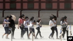 South Korean students wear masks as a precaution against Middle East Respiratory Syndrome (MERS) virus as they visit Gyeongbok Palace in Seoul, South Korea, Wednesday, June 3, 2015. (AP Photo/Ahn Young-joon)