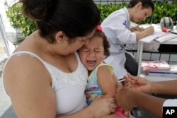 In this March 2, 2018 photo, a child cries out as she is given a vaccine against yellow fever at a public health post set up on the outskirts of Sao Paulo, Brazil.