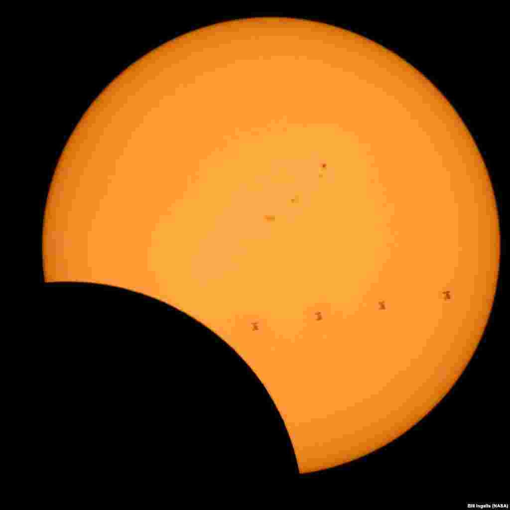 This composite image, made from four frames, shows the International Space Station, with a crew of six onboard, as it transits the Sun at roughly five miles per second during a partial solar eclipse, from Northern Cascades National Park in Washingtron.