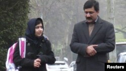 Malala Yousufzai walks with her father Ziauddin as she attends Edgbaston High School for girls in Edgbaston, England March 19, 2013