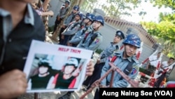 Police block protestors outside the Thai embassy in Yangon.
