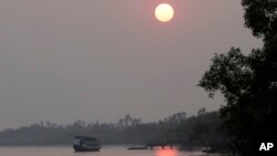 A ferry carrying tourists moves towards a jetty at Bali village in the Sundarbans, India, Jan. 31, 2015. Thousands are homeless as seas rise twice as fast as the global average and water eats away at the islands in this vast region called the Sundarbans.