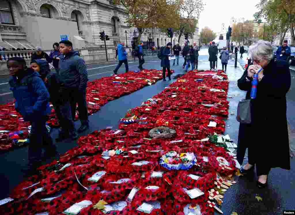 People look at poppy wreaths left around the Cenotaph after yesterday&#39;s remembrance ceremonies to mark the centenary of the end of World War 1, in London, Britain.