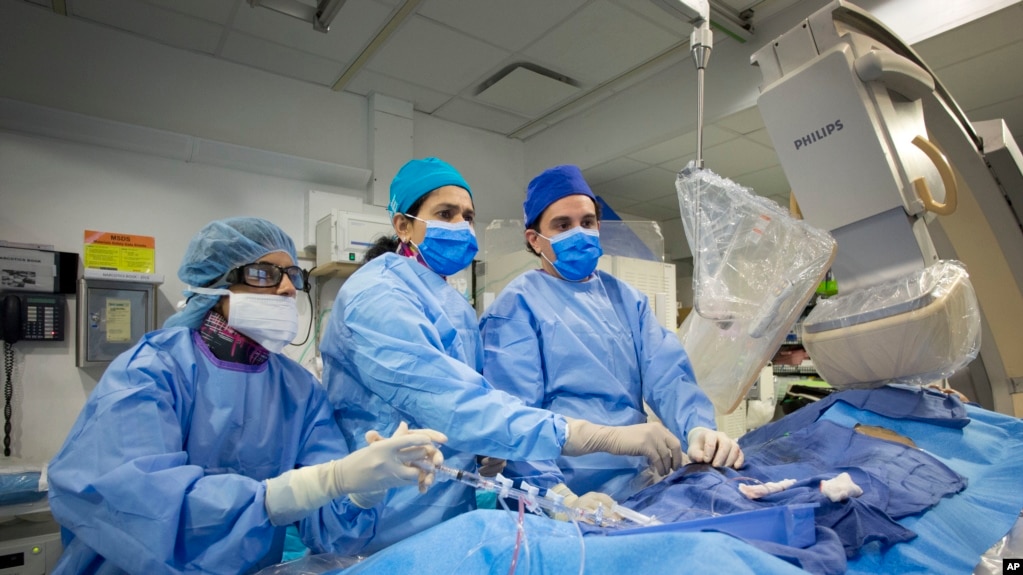 En esta foto del 16 de febrero de 2017, el Dr. Annapoorna Kini, centro, realiza una cirugía en el Hospital Mount Sinai en Nueva York. 