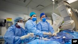 En esta foto del 16 de febrero de 2017, el Dr. Annapoorna Kini, centro, realiza una cirugía en el Hospital Mount Sinai en Nueva York. 