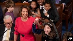 With some enthusiastic assistance from her grandchildren, House Democratic Leader Nancy Pelosi of California smiles as she casts her vote for herself to be speaker of the House on the first day of the 116th Congress, at the Capitol in Washington, Jan. 3,
