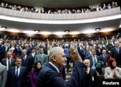Turkey's Prime Minister Binali Yildirim greets members of parliament from his ruling AK Party as he arrives for a meeting at the Turkish parliament in Ankara, April 18, 2017.