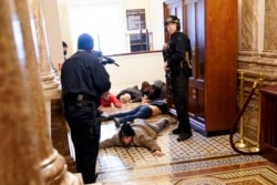 U.S. Capitol Police hold protesters at gun-point near the House Chamber inside the U.S. Capitol on Wednesday, Jan. 6, 2021, in Washington. (AP Photo/Andrew Harnik)