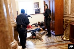 U.S. Capitol Police hold protesters at gun-point near the House Chamber inside the U.S. Capitol on Wednesday, Jan. 6, 2021, in Washington. (AP Photo/Andrew Harnik)