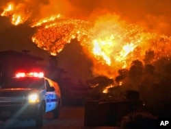 FILE - In this photo provided by the Santa Barbara County Fire Department, fire burns canyons and ridges above Bella Vista Drive near Romero Canyon in Montecito, Calif., Dec. 12, 2017.