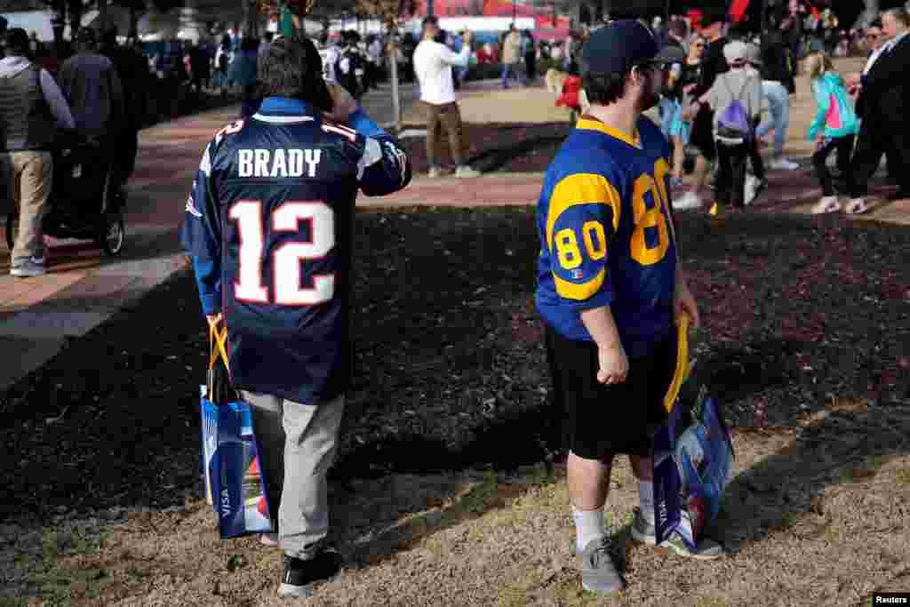 Fans dressed in New England Patriots and Los Angeles Rams jerseys attend an NFL fan celebration in Centennial Park outside Mercedes Benz Stadium ahead of Super Bowl LIII in Atlanta, Feb. 2, 2019.