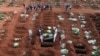 Para penggali kubur yang mengenakan APD menurunkan peti mati seseorang yang meninggal karena COVID-19 di pemakaman Vila Formosa di Sao Paulo, Brazil. Jumlah kematian akibat COVID-19 di Brazil mencapai rekor lebih dari 4.000 orang meninggal dalam sehari (7/4).