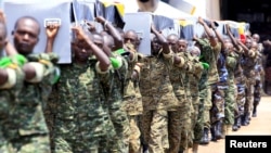 FILE - Uganda army soldiers at a military airbase in Entebbe carry the caskets containing the remains of Ugandan soldiers who were killed in Somalia during the week, Sept. 3, 2015.