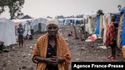 FILE - A woman walks at the Kayembe camp for dislaced persons, near Goma, Democratic Republic of Congo, Aug. 30, 2021.
