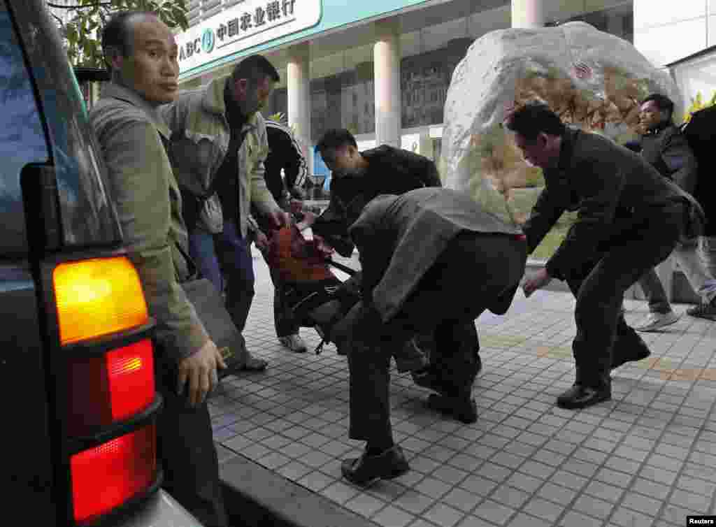 2013年1月10日，在广州《南方周末》总部附近，一名抗议者被便衣警察带走，塞入一辆吉普车。