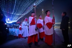 FILE - Cross-bearers lead procession into the Southern Cathedral, an officially-sanctioned Catholic church in Beijing, China, Thursday, Dec. 24, 2015. (AP Photo/Mark Schiefelbein)