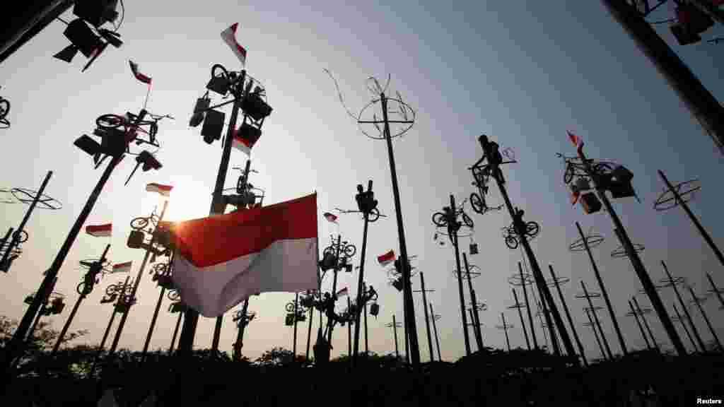 People take part in a game of &quot;Panjat Pinang&quot;, where people climb poles to collect prizes, during Independence Day celebrations in Jakarta, Indonesia, Aug. 18, 2018, in this photo taken by Antara Foto.