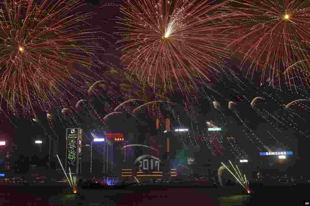 Fuegos artificiales explotan sobre el puerto de Victoria para celebrar la víspera de Año Nuevo en Hong Kong. (Foto AP)