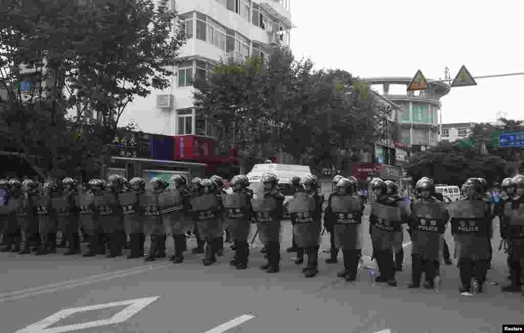 Riot police stand in a line to guard a street during a protest in Shifang, Sichuan province, China, July 3, 2012.