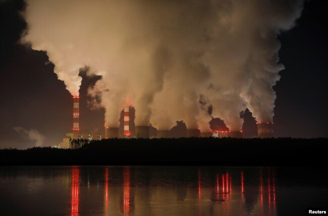 FILE - Smoke and steam billows from Belchatow Power Station, Europe's largest coal-fired power plant, operated by PGE Group, at night near Belchatow, Poland, Dec. 5, 2018.