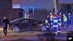 Petugas kepolisian dan pemadam kebakaran memeriksa mobil yang ditumpangi PM Polandia, Beata Szydlo, yang terlibat dalam kecelakaan (10/2). Oswiecim, Polandia. (foto: AP Photo)