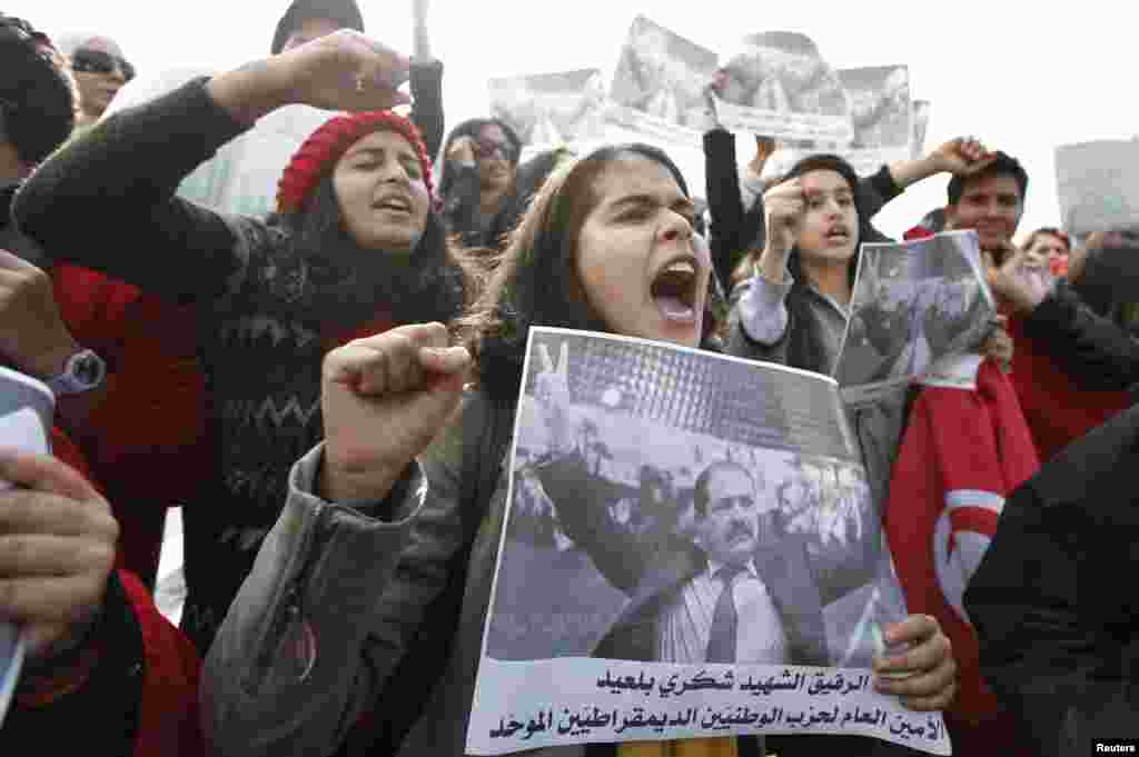 Para remaja dan kalangan muda melakukan unjuk rasa sambil membawa foto tokoh oposisi Chokri Belaid yang tewas terbunuh. Demonstran pendukung oposisi menuntut mundurnya PM Hamadi Jebali dan kabinetnya dalam aksi protes di Tunis, Tunisia (11/2).