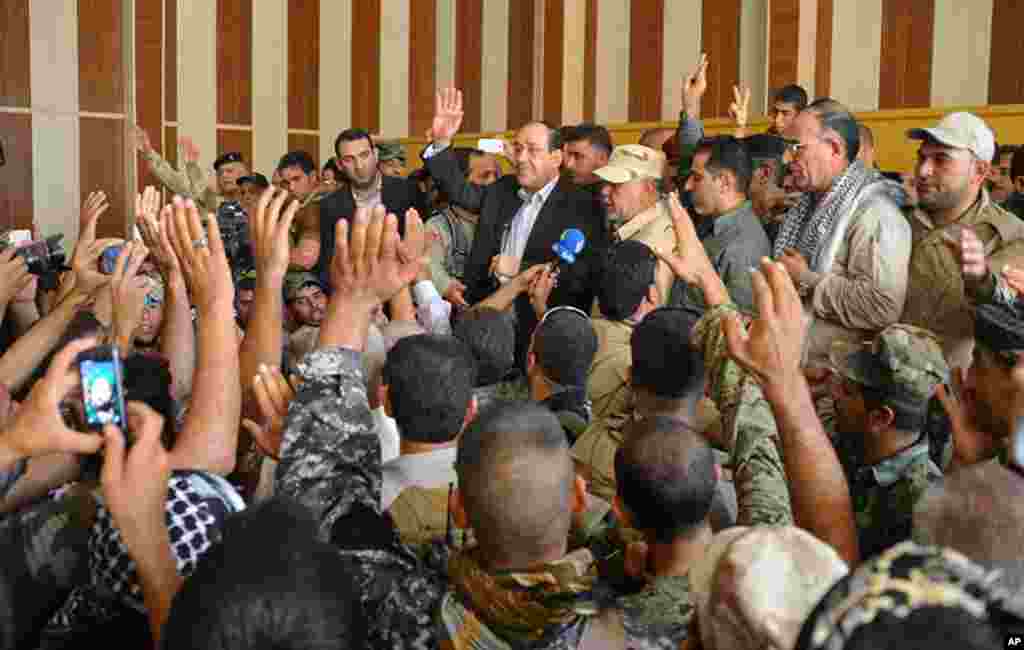 In this photo provided by the Iraqi government, outgoing Prime Minister Nouri al-Maliki, center, is surrounded by residents and security forces after his arrival in Amerli, some 170 kilometers north of Baghdad, Iraq, Sept. 1, 2014.