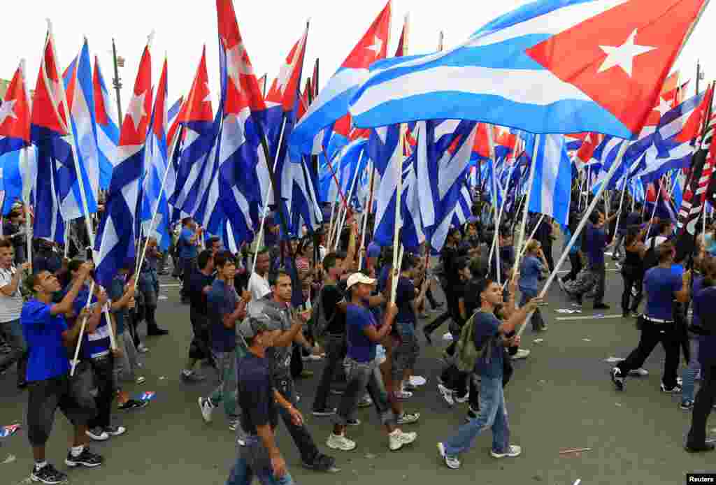Youths carry Cuban flags during the May Day parade in Havana's Revolution Square May 1, 2013.
