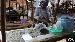 A woman sells odowa stones at a roadside market in Nairobi, Kenya (R. Ombuor/VOA).
