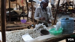 A woman sells odowa stones at a roadside market in Nairobi, Kenya (R. Ombuor/VOA). Seorang perempuan menjual batu odowa di pinggir jalan