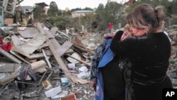 Seorang tetangga menenangkan Lida Sarksyan (kiri) setelah rumahnya hancur oleh serangan dari pasukan Azerbaijan, di Stepanakert, wilayah separatis Nagorno-Karabakh, Sabtu, 17 Oktober 2020. (Foto: AP)