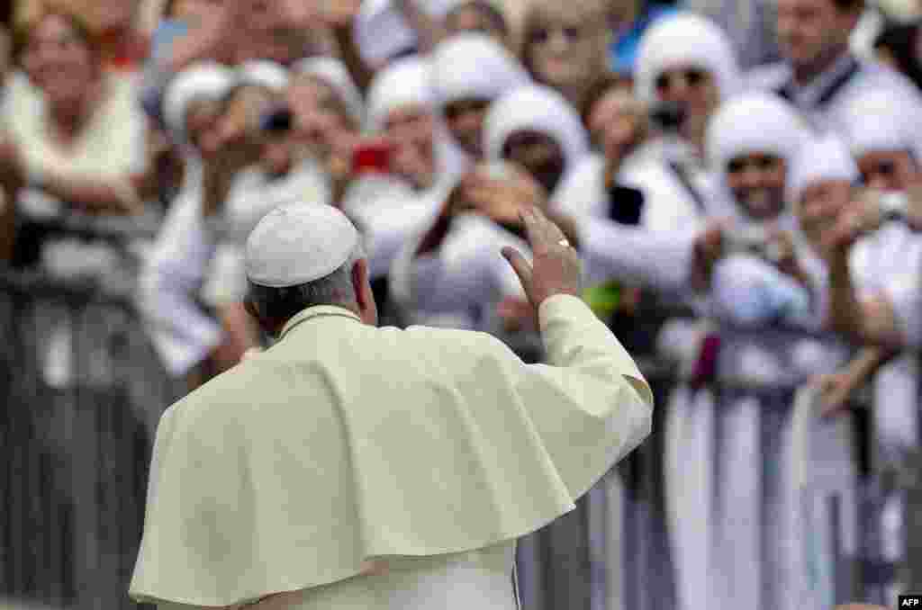 Pope Francis waves to nuns at the end of his weekly general audience in St Peter&#39;s Square at the Vatican.