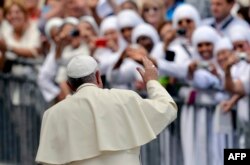 FILE - Pope Francis waves to nuns at the end of his weekly general audience in St Peter's square at the Vatican on September 17, 2014.