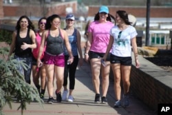 A group of first-year female students at Slippery Rock University smile for the camera as they enjoy temperatures in the 70s on a walk across campus in Slippery Rock, Pa., Feb. 24, 2017.
