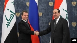 Russian Prime Minister Dmitry Medvedev shake hands with Iraq's Prime Minister Nouri Al-Maliki, right, prior to their meeting in the Gorki residence outside Moscow, October 9, 2012.