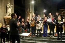 In this photo taken Monday, Dec. 16, 2019, Notre Dame cathedral choir's director Henri Chalet directs the Notre Dame choir during a rehearsal at the Saint Sulpice church in Paris. (AP Photo/Michel Euler)