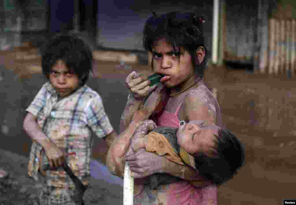 Children from the Esse Ejja ethnic group are seen after the flooding in Rurrenabaque, some 286 km (178 miles) of Trinidad in Bolivia, Feb. 13, 2014. Floodwaters continue to sweep across the country and authorities work to rush food and aid to victims, according to local media.